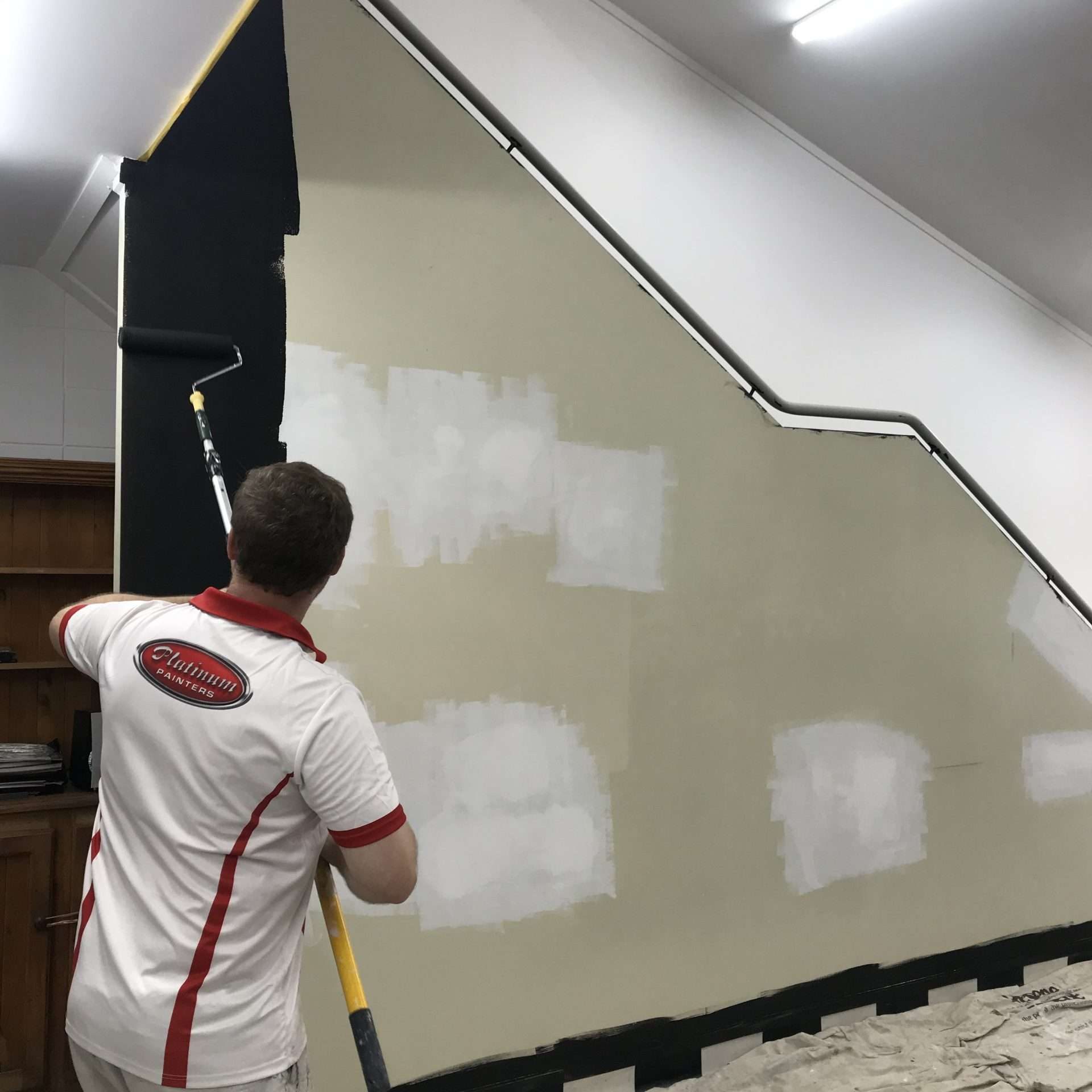 man painting a wall with a roller